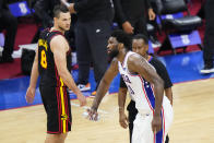 Philadelphia 76ers' Joel Embiid, right, tosses a beer can that was thrown onto the court as Atlanta Hawks' Danilo Gallinari looks on during the final minutes of Game 7 in a second-round NBA basketball playoff series, Sunday, June 20, 2021, in Philadelphia. The 76ers face an uncertain future after an early exit in the playoffs. (AP Photo/Matt Slocum)