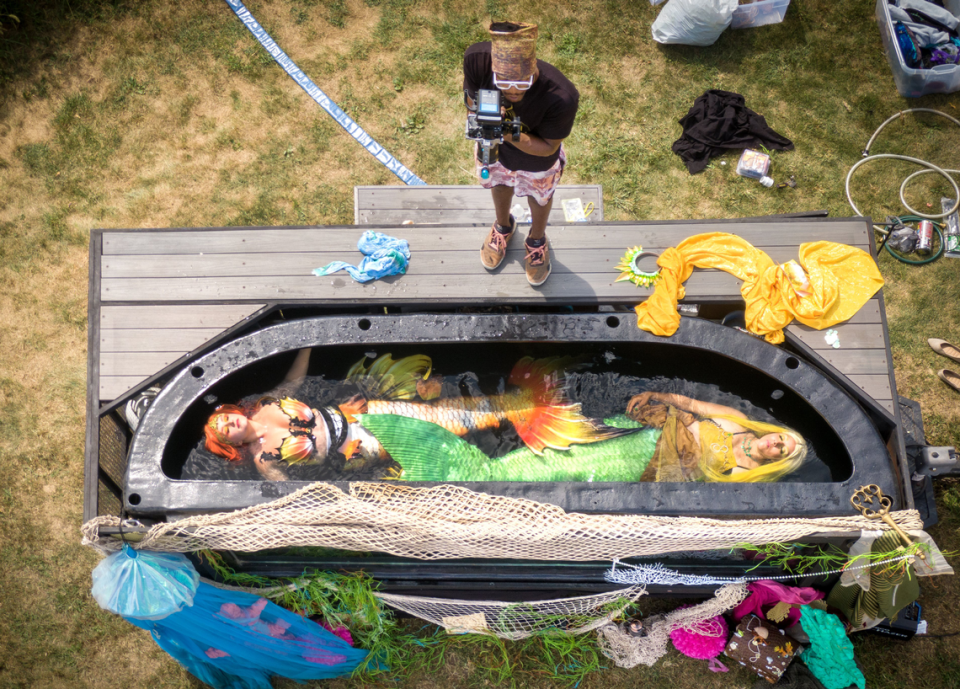 Aurora Rose Watkins as Mermaid Nellie, left, and Nicole Loudon as Mermaid Citrise, right, float in a 3,000 gallon tank as Jor-El Washington operates a camera during the filming of a promotional video. Tammy Ljungblad/tljungblad@kcstar.com