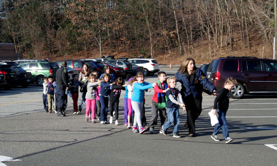 Two Connecticut State Police officers accompany a class of students and two adults out of Sandy Hook Elementary School on Dec. 14, 2012. (Photo: Shannon Hicks/Newtown Bee/Polaris)