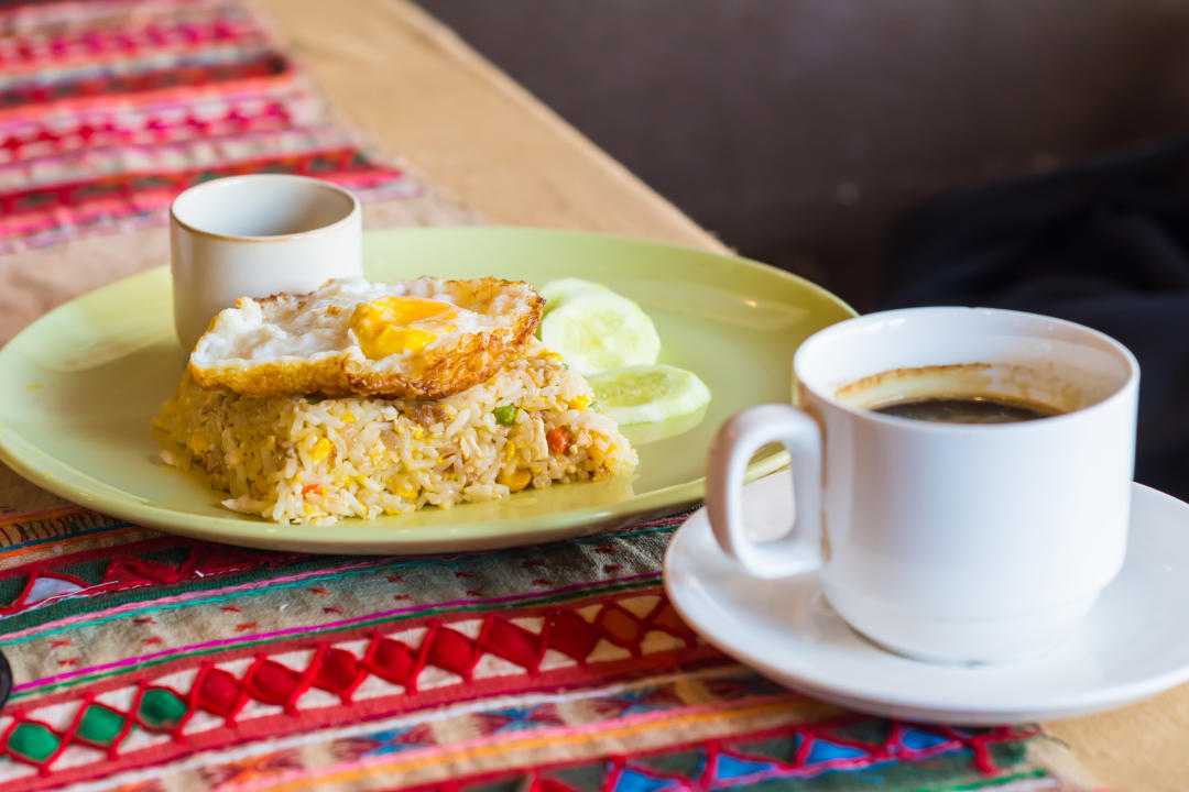 fried rice with and fried egg. cup coffee.