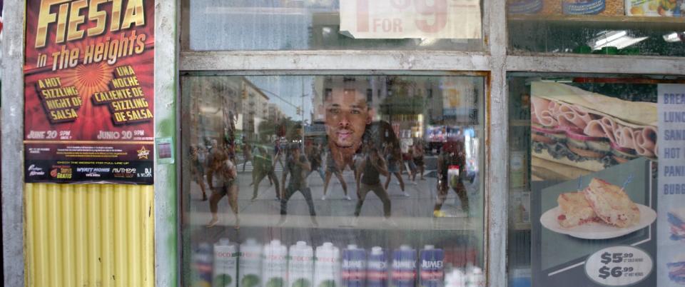 A man looks through the reflection in a glass window.