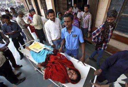 A woman, who underwent a sterilization surgery at a government mass sterilisation "camp", lies in a stretcher before she is shifted to a private hospital from the Chhattisgarh Institute of Medical Sciences (CIMS) hospital in Bilaspur, in the eastern Indian state of Chhattisgarh, November 13, 2014. REUTERS/Anindito Mukherjee