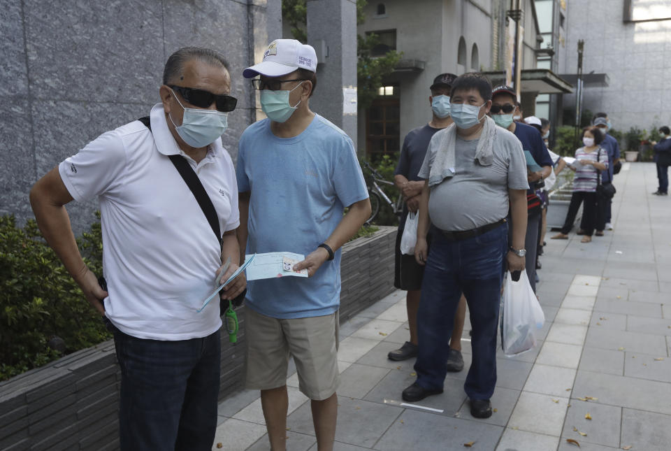 Members of the Nationalist Party, or KMT, wait to cast their ballot for election of its party chairman at a polling station in Taipei, Taiwan, Saturday, Sept. 25, 2021. Fraught relations with neighboring China are dominating Saturday's election for the leader of Taiwan’s main opposition Nationalist Party. (AP Photo/Chiang Ying-ying)