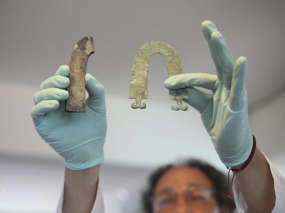 Jedu Sadarnaga shows jewellery on November 15, 2018 from one of the tombs found at a Bolivian quarry near the capital of La Paz. The tombs contained remains belonging to more than 100 individuals and were buried with more than 30 vessels used by the Incas. (AP/Luis Gandarillas)