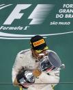 Formula One - F1 - Brazilian Grand Prix - Circuit of Interlagos, Sao Paulo, Brazil - 13/11/2016 - Mercedes' Lewis Hamilton of Britain kisses his trophy during the victory ceremony after winning the race. REUTERS/Nacho Doce