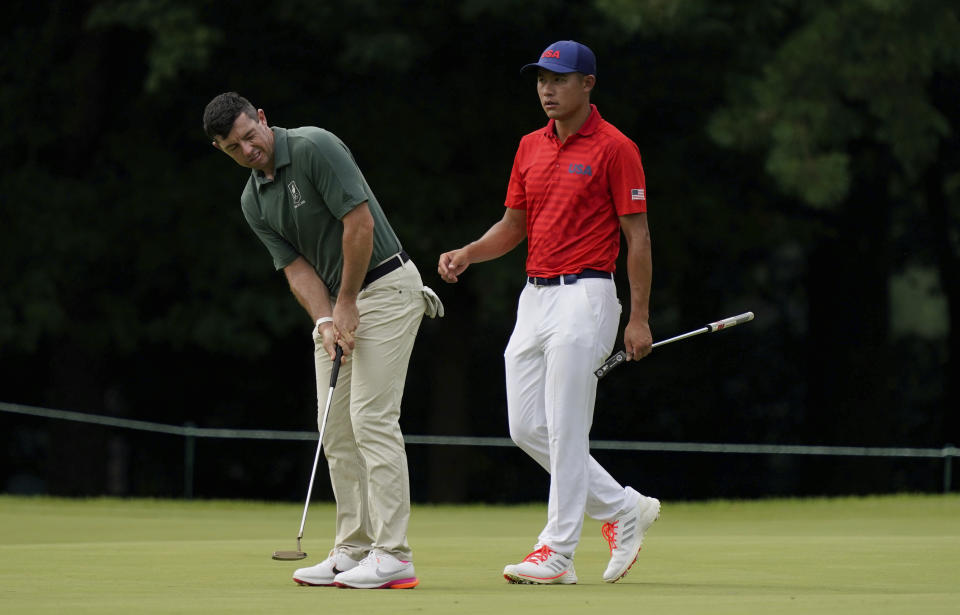 Rory McIlroy of Ireland, left, studies his putt beside Collin Morikawa of United States on the third green during the second round of the men's golf event at the 2020 Summer Olympics on Friday, July 30, 2021, at the Kasumigaseki Country Club in Kawagoe, Japan. (AP Photo/Matt York)