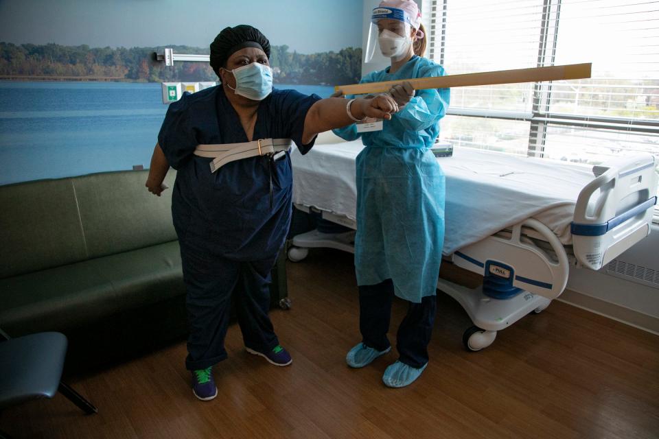 Charlunda Thompson, 45, of Inkster, left, works with Lauren Lenca, a physical therapist at Mary Free Bed Rehabilitation Hospital in Grand Rapids as she recovers from COVID-19.