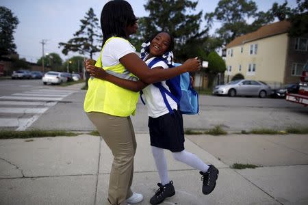 Safe Passage worker Irene Fonder gets a hug from a Sherwood Elementary School student in the Englewood neighborhood in Chicago, Illinois, United States, September 8, 2015. REUTERS/Jim Young