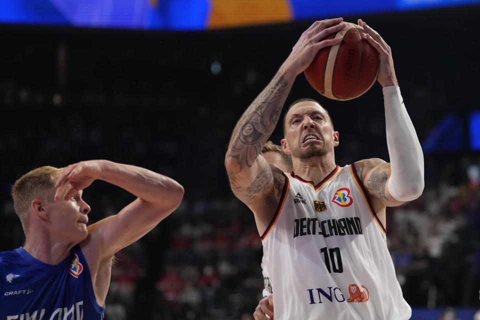 Germany forward Daniel Theis (10) tries to keep a rebound against Finland guard Sasu Salin (9) in the first half of their Basketball World Cup group E match in Okinawa, southern Japan, Tuesday, Aug. 29, 2023. (AP Photo/Hiro Komae)