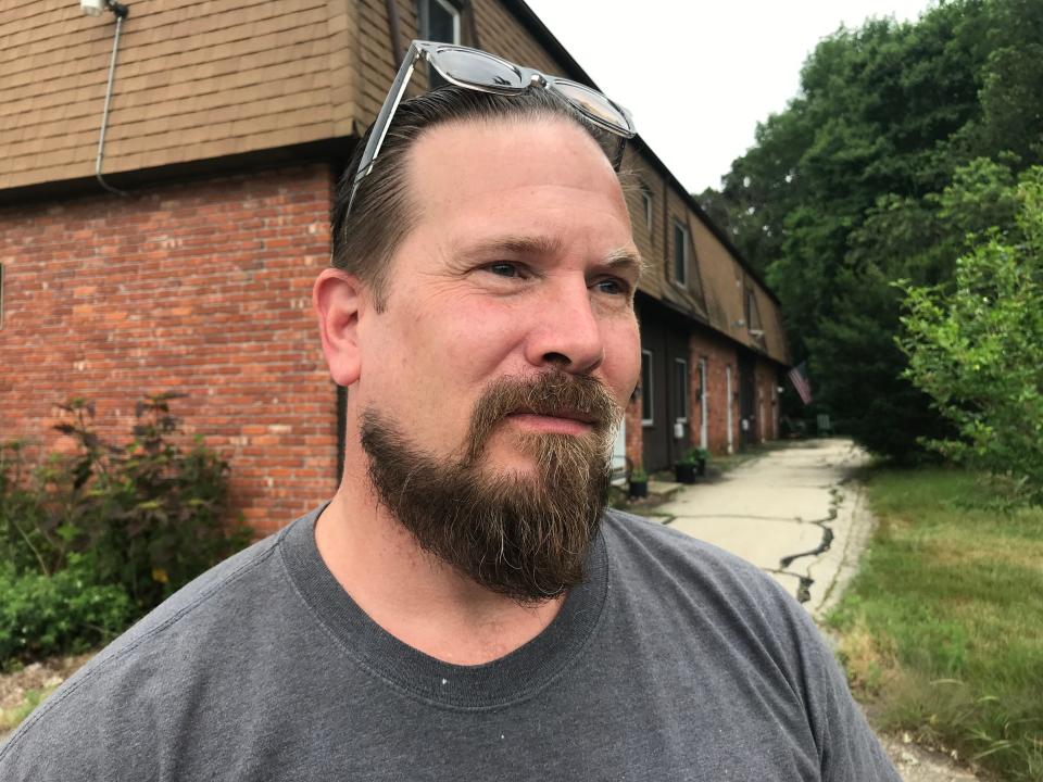 Paul Moore, 49, stands in front of the apartments he moved into after his mother returned home when he was 13.