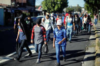 People walk in a caravan of migrants departing from El Salvador en route to the United States, in San Salvador, El Salvador, November 18, 2018. REUTERS/Jose Cabezas