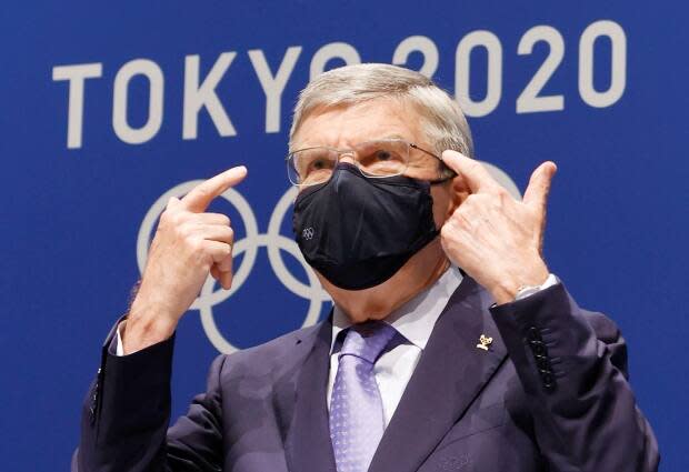 IOC president Thomas Bach gestures during a press conference ahead of the Tokyo Olympics. The Games forge on despite the risk of COVID-19 eliminating top athletes from competition.  (Shinji Kita/Kyodo News via AP - image credit)