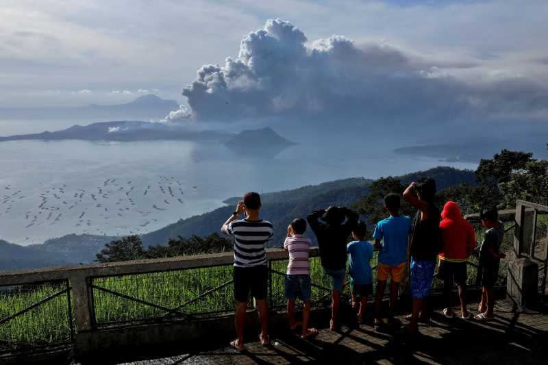 塔爾火山噴發讓當地居民十分緊張，但也有部分觀光客反其道而行，前往靠近火山的城鎮，只為了找到更進更好的角度觀賞這番「奇景」。（圖／達志／路透社）