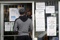 CORRECTS TO CULVER CITY, INSTEAD OF LOS ANGELES An employee answers questions at the entrance to a gun shop Tuesday, March 24, 2020, in Culver City, Calif. Los Angeles County Sheriff Alex Villanueva said he would like to see gun shops shut down. "We will be closing them, they are not an essential function," Villanueva said. Adding guns to households where more people are at home during a crisis increases the risk that someone will be shot, he said. (AP Photo/Marcio Jose Sanchez)