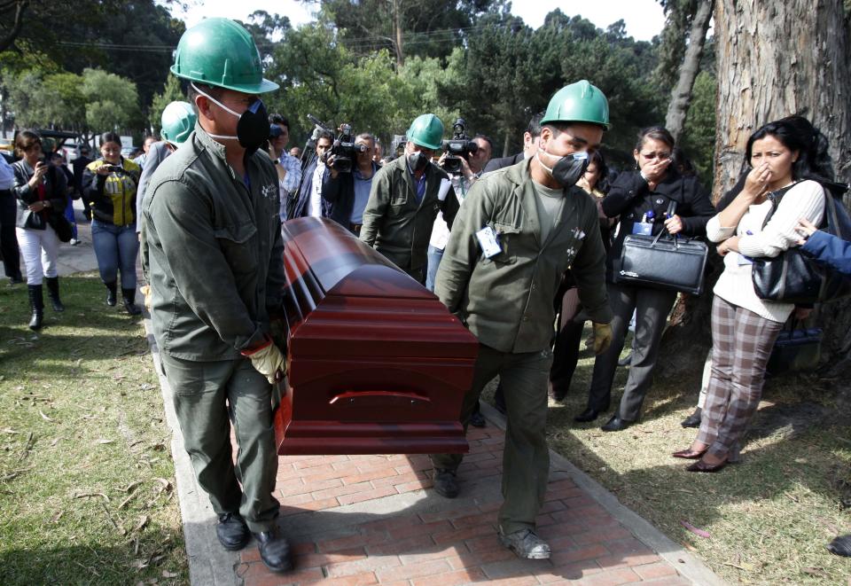 FILE - In this Feb. 22, 2011 file photo, cemetery workers carry the coffin with the remains of Revolutionary Armed Forces of Colombia, FARC, guerrilla leader Victor Suarez Rojas, also known as Jorge Briceno or Mono Jojoy, to his cemetery plot in Bogota, Colombia. The top peace negotiator for the FARC announced Thursday,Aug. 29, 2019, that he and a cadre of hardline supporters are taking up arms again, accusing President Ivan Duque of failing to uphold the accord that sought to end a half century of bloody fighting. (AP Photo/Fernando Vergara, File)