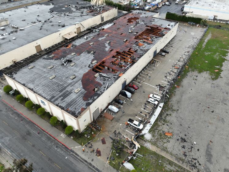 Montebello, CA - March 22: Crews start to clean up debris after a strong microburst -- which some witnesses dubbed a possible tornado -- which injured one person and heavily damaged several cars and buildings, including the roof of the Royal Paper Box Company, shown in photo, in Montebello Wednesday, March 22, 2023. Five buildings have been damaged and one has been red-tagged. Video from the scene showing portions of rooftops being ripped off industrial structures and debris swirling in the air. The National Weather Service on Tuesday night issued a brief tornado warning in southwestern Los Angeles County, but it was allowed to expire after about 15 minutes when weather conditions eased. There was no such warning in place late Wednesday morning when the powerful winds hit Montebello, near the area of Washington Boulevard and Vail Avenue. (Allen J. Schaben / Los Angeles Times)