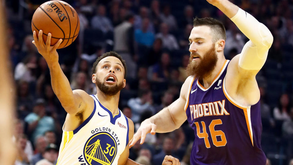 Golden State guard Steph Curry, left, broke his hand after colliding with Phoenix center Aron Baynes. (Photo by Ezra Shaw/Getty Images)