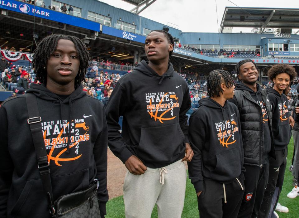 Members of the North High School state champion basketball team participate in the pre-game ceremony on opening day at Polar Park Tuesday.