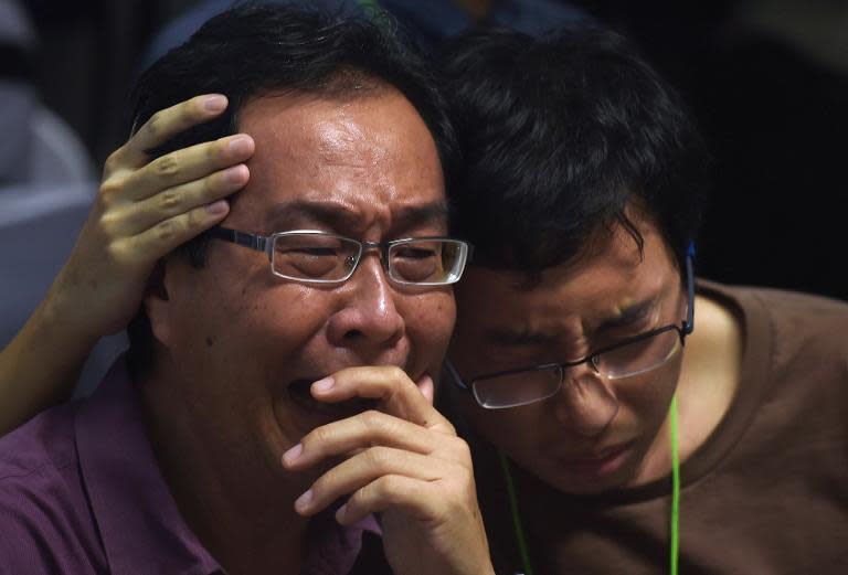 Family members of passengers onboard AirAsia flight QZ8501 react after watching news reports showing a body floating in the Java Sea, while waiting at a crisis-centre set up at Juanda International Airport in Surabaya, on December 30, 2014