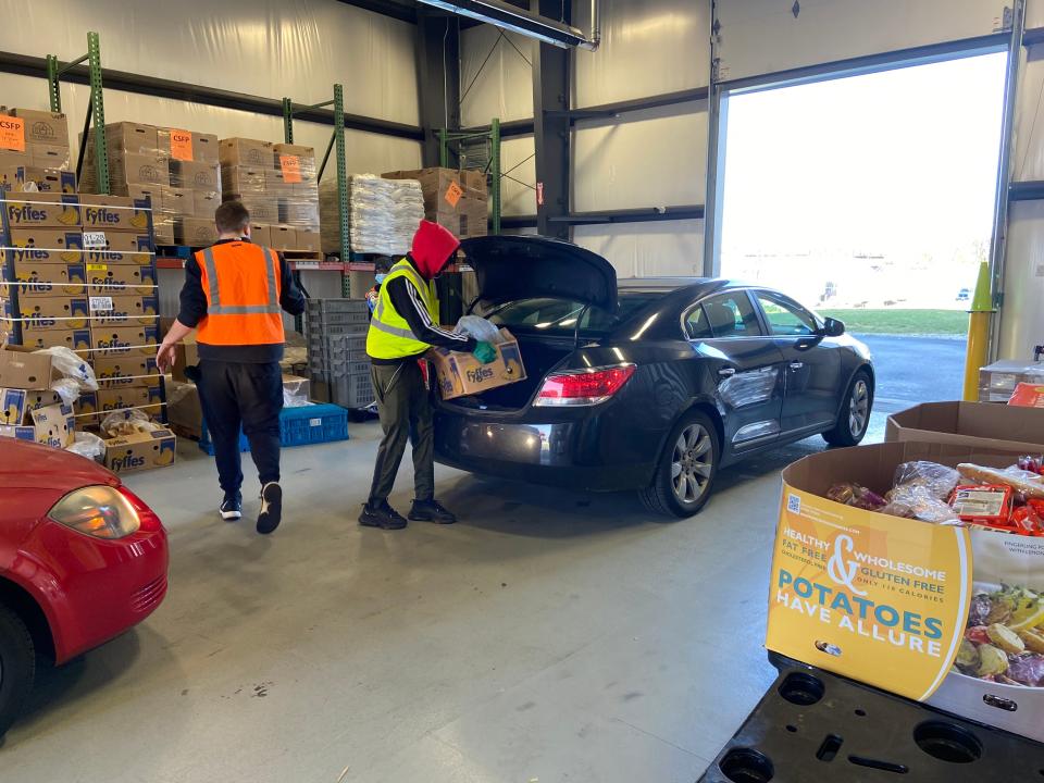 Volunteers at The Foodbank Inc. in Dayton, Ohio, load boxes of food into cars during the twice-weekly drive-thru distribution.