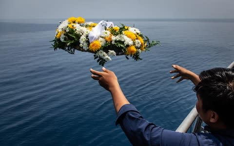 A family of victims of Lion Air flight JT 610 throw a bouquet of flowers during visit to the site of the crash - Credit: Ulet Ifansasti/Getty Images