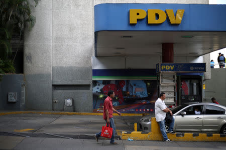 FILE PHOTO: A pedestrian walks next to a PDVSA gas station in Caracas, Venezuela, January 28, 2019. REUTERS/Andres Martinez Casares/File Photo