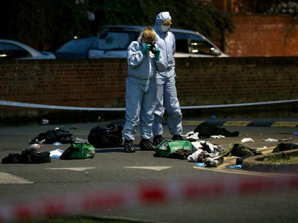Forensics officers inspect the area outside Landor House, Camberwell, London, after four people were taken to hospital with stab wounds: PA