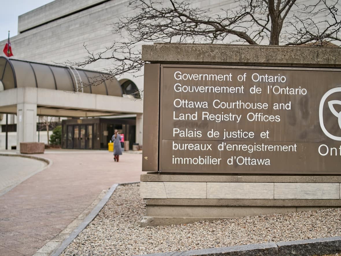 A person walks toward the main entrance of the Ottawa Courthouse on Elgin Street on March 30, 2022.                           (David Richard/CBC - image credit)