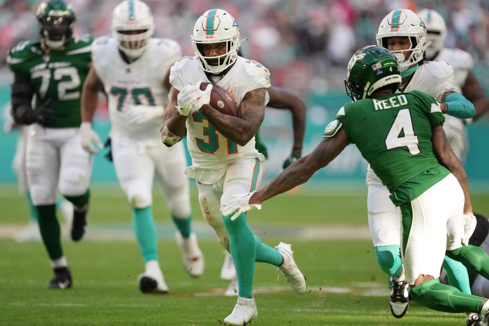 Miami Dolphins running back Raheem Mostert (31) breaks free for a big gain as New York Jets cornerback D.J. Reed (4) closes in during the second half of an NFL game at Hard Rock Stadium in Miami Gardens, Dec. 17, 2023.