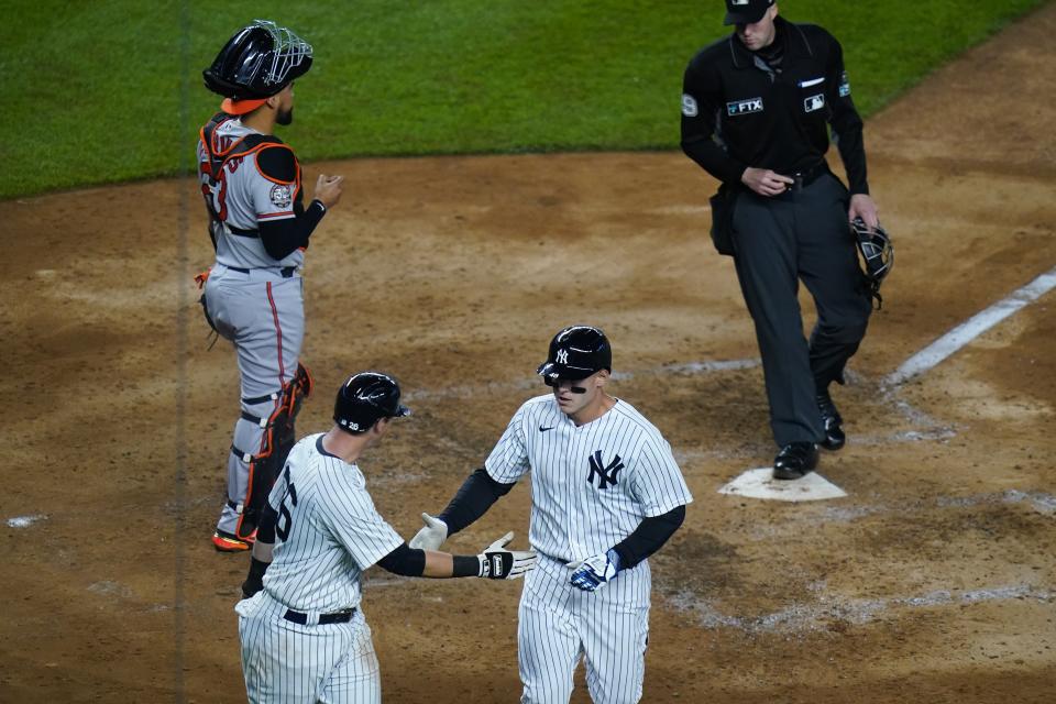 New York Yankees' Anthony Rizzo, right, celebrates with DJ LeMahieu as Baltimore Orioles catcher Robinson Chirinos looks away after they scored on a Rizzo's two-run home run during the fifth inning of a baseball game Tuesday, April 26, 2022, in New York. (AP Photo/Frank Franklin II)