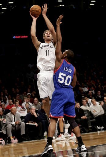 Brooklyn Nets' Brook Lopez, top, takes a shot over Philadelphia 76ers' Lavoy Allen during the first half of the NBA basketball game at the Barclays Center Sunday, Dec. 23, 2012 in New York. (AP Photo/Seth Wenig)