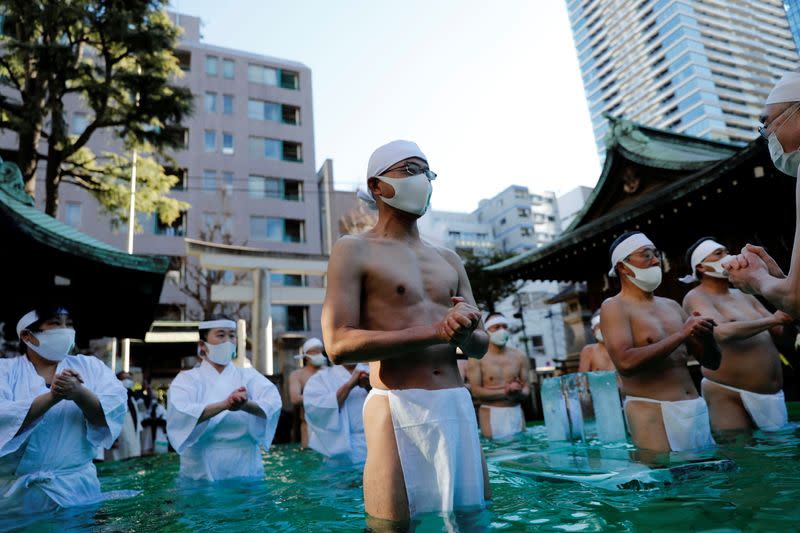 Participants wearing protective face masks amid the coronavirus disease (COVID-19) outbreak, take an ice-cold bath at a ceremony in Tokyo