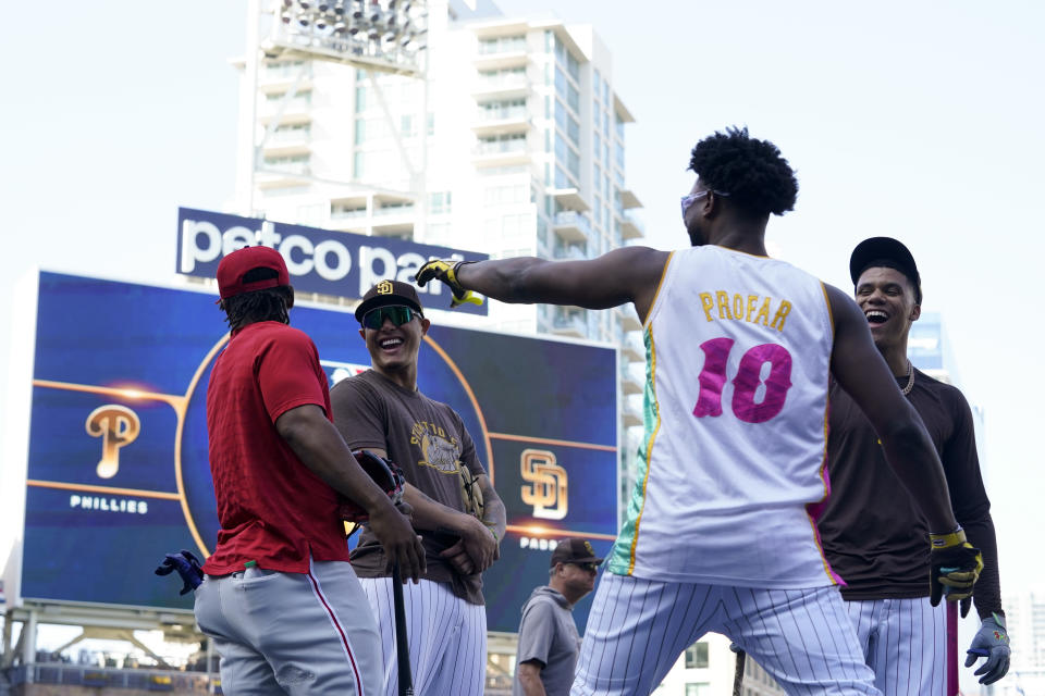 San Diego Padres left fielder Jurickson Profar (10) tries to grab the cap from Philadelphia Phillies second baseman Jean Segura, left, as Padres third baseman Manny Machado, center, and right fielder Juan Soto, right, look on during practice ahead of Game 1 of the baseball NL Championship Series Monday, Oct. 17, 2022, in San Diego. The Padres host the Phillies for Game 1 Oct. 18. (AP Photo/Gregory Bull)