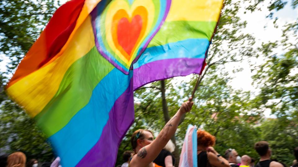 Ein Teilnehmer der «CSD Berlin Pride» trägt eine Regenbogenfarbene Flagge mit einem Herz. (Symbolbild)