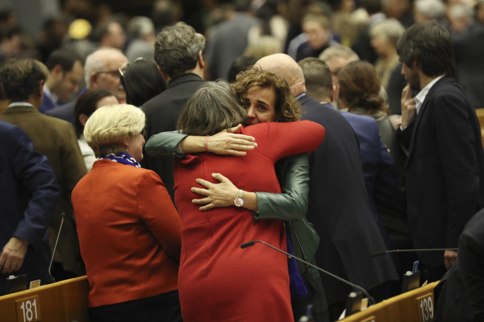 MEP's embrace after a vote on the UK's withdrawal from the EU, the final legislative step in the Brexit proceedings, during the plenary session at the European Parliament in Brussels, Wednesday, Jan. 29, 2020. The U.K. is due to leave the EU on Friday, Jan. 31, 2020, the first nation in the bloc to do so. (AP Photo/Francisco Seco, Pool)