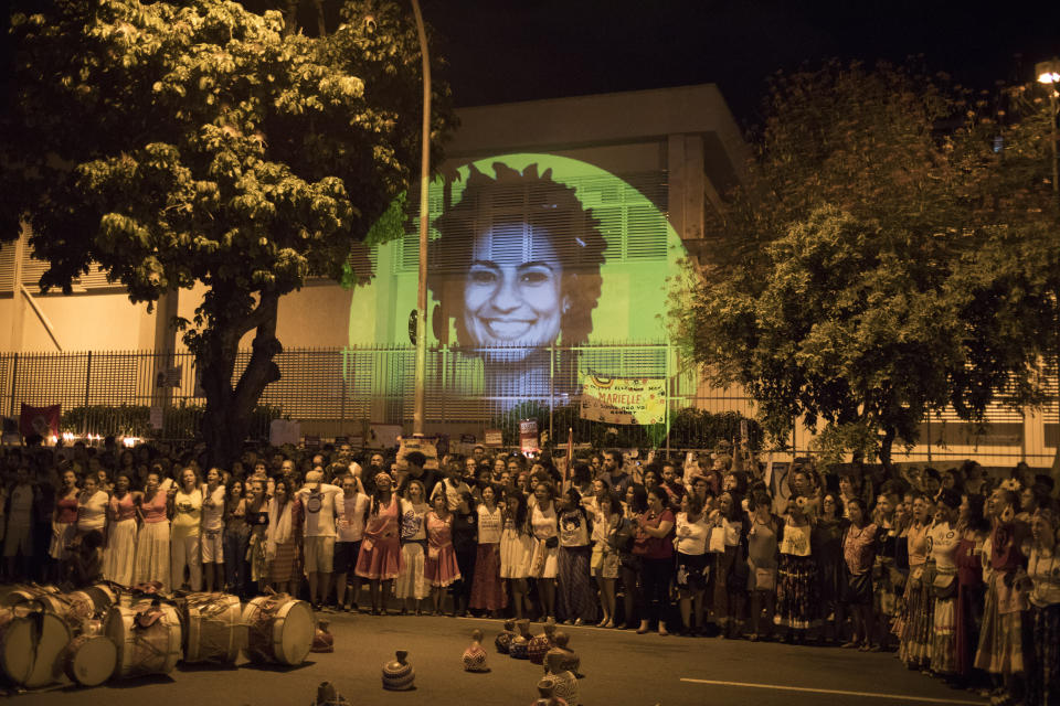 FILE - An image of slain councilwoman Marielle Franco is projected on a wall, where people gather to protest at the site where Franco and her driver Anderson Pedro Gomes were killed, during a protest in Rio de Janeiro, Brazil, April 14, 2018. A rising political star Franco resisted militias' expansion. (AP Photo/Leo Correa, File)