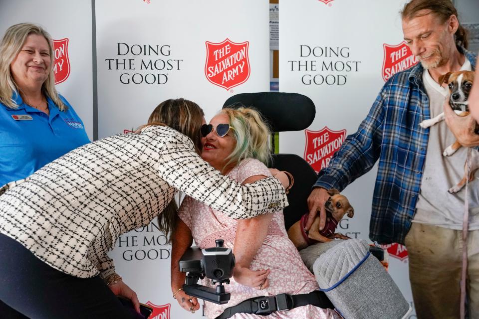 Collier Community Foundation Vice President of Community Engagement Lindsey Touchette hugs Angie Beer after Beer received her new electric wheelchair at the Salvation Army in Naples on Wednesday, Feb. 15, 2023. 