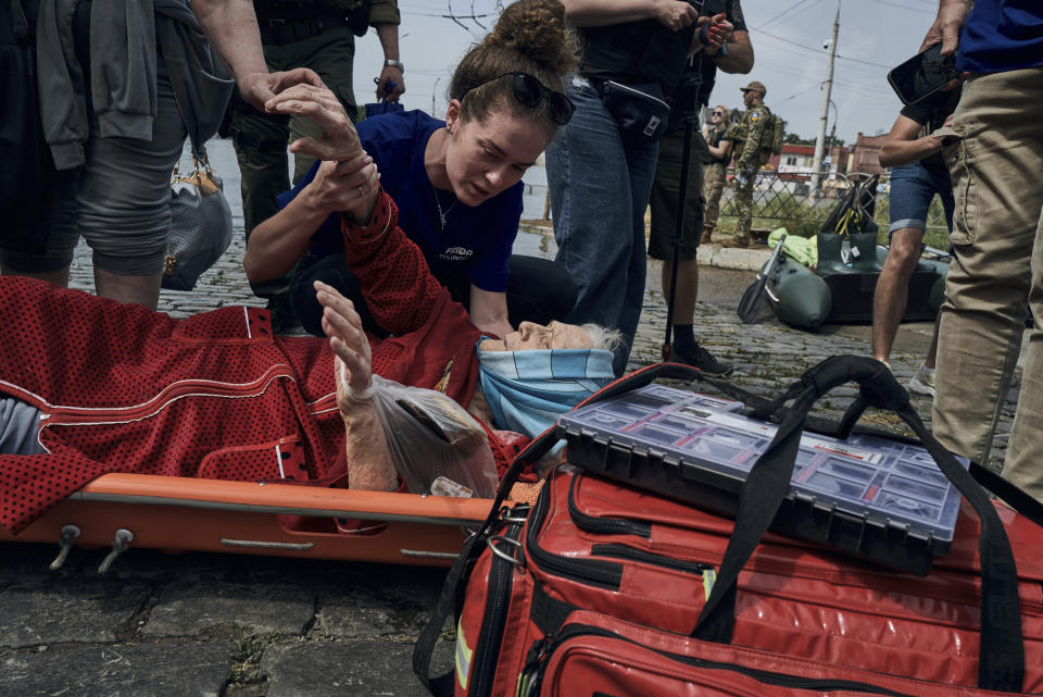 FILE - Emergency workers evacuate an elderly resident from a flooded neighbourhood in Kherson, Ukraine, Thursday, June 8, 2023. Floodwaters from a collapsed dam kept rising in southern Ukraine on Thursday, forcing hundreds of people to flee their homes in a major emergency operation that brought a dramatic new dimension to the war with Russia, now in its 16th month. (AP Photo/Libkos, File)