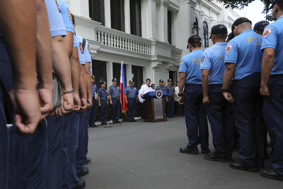 In this photo provided by the Presidential Photographers Division, Malacanang Palace, Philippine President Rodrigo Duterte, center by the podium, speaks to erring policemen during an audience at the Presidential Palace grounds in Manila, Philippines, Tuesday, Feb. 9, 2017. Duterte angrily berated more than 200 allegedly erring policemen and said he would send them to a southern island to fight extremists dreaded for their beheadings. Duterte's expletive-filled outburst against the officers at the palace was his latest tirade against a police force that he has called "rotten to the core." He recently banned the national police from carrying out his anti-drug campaign after a group of officers used the crackdown as a cover to kidnap and kill a South Korean man in an extortion scandal. (King Rodriguez/Presidential Photographers Division, Malacanang Palace via AP)