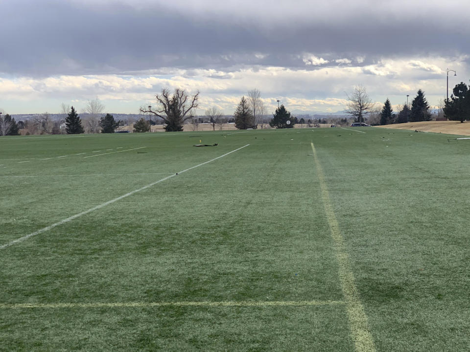 In this photo provided by the Broomfield Police Department on Twitter, debris is scattered across a turf field at Commons Park, Saturday, Feb. 20, 2021, in Broomfield, Colo. The police ask that the area be avoided if possible. A commercial airliner dropped debris in Colorado neighborhoods during an emergency landing Saturday. The Broomfield Police Department said on Twitter that the plane landed safely at Denver International Airport and that no injuries had been reported from the incident. (Broomfield Police Department via AP)