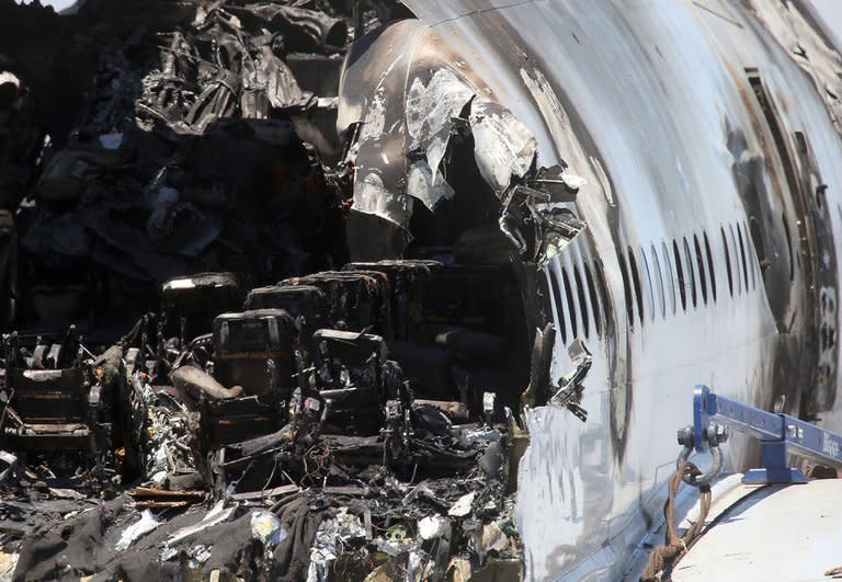 Burned seats are visible in the wrecked fuselage of Asiana Airlines flght 214 as it sits in a storage area at San Francisco International Airport on July 12, 2013. A third girl, reportedly Chinese, died of injuries sustained in the Asiana jet crash in San Francisco, as authorities confirmed that a firetruck ran over one of the other victims