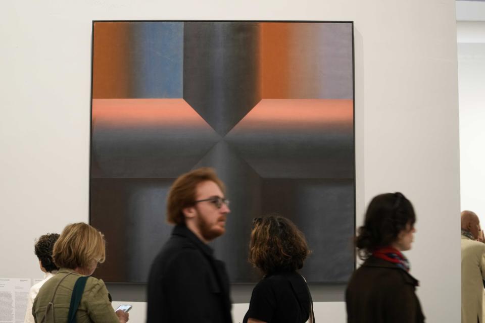 A visitor walks next to the painting "Black is Beautiful," by Palestinian artist Samia Halaby at the 60th Biennale of Arts exhibition in Venice, Italy, Tuesday, April 16, 2024. The Venice Biennale contemporary art exhibition opens Saturday for its six-month run through Nov. 26. (AP Photo/Luca Bruno)