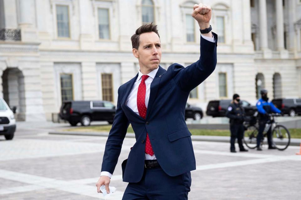 ONE TIME USE 1/7/2021 Sen. Josh Hawley (R-Mo.) gestures toward a crowd of supporters of President Donald Trump gathered outside the U.S. Capitol to protest the certification of President-elect Joe Biden's electoral college victory Jan. 6, 2021 at the US Capitol in Washington, DC. Some demonstrators later breached security and stormed the Capitol.