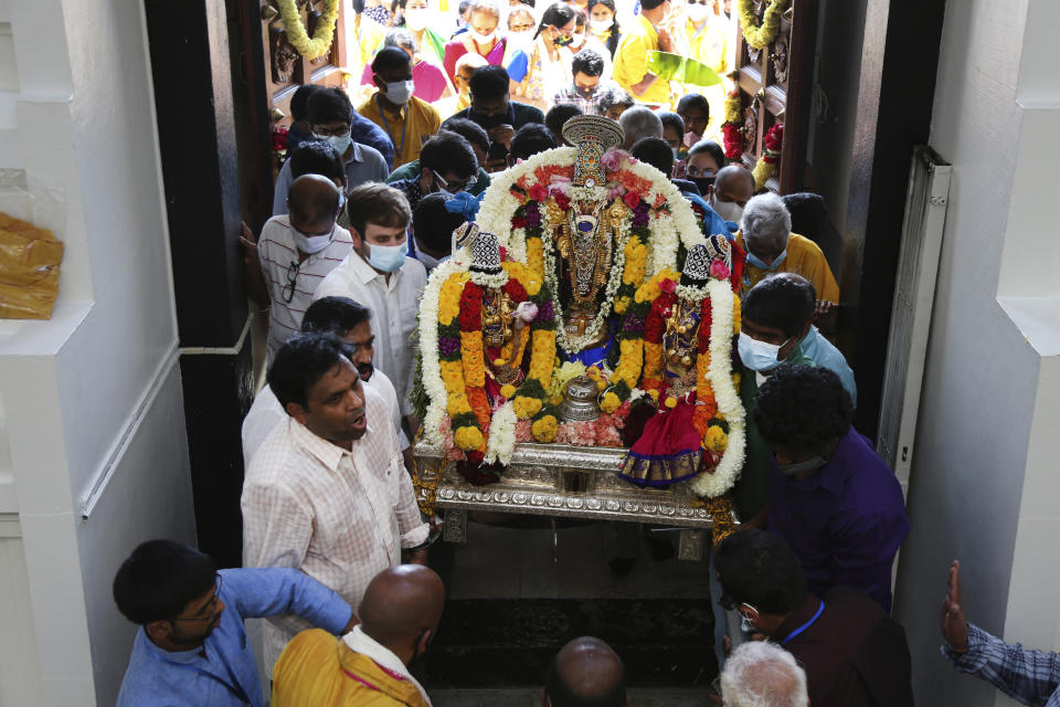 Sri Venkateswara Temple devotees and volunteers carry a deity back into the temple during Maha Kumbhabhishekam, a five-day Hindu rededication ceremony in Penn Hills, Pa., Sunday, June 27, 2021. Built in the 1970s, the Sri Venkateswara Temple is the oldest major Hindu temple in the country. Maha Kumbhabhishekams occur about every 12 years and involve ceremonies to reenergize the temple and its deities. (AP Photo/Jessie Wardarski)