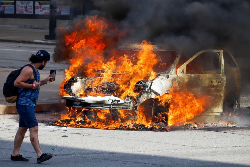 A Pittsburgh Police vehicle burns during a during a march in Pittsburgh, Saturday, May 30, 2020 to protest the death of George Floyd, who died after being restrained by Minneapolis police officers on Memorial Day, May 25. Saturday, May 30, 2020.