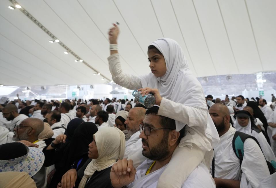 A Muslim girl casts stone in the symbolic stoning of the devil ritual during the Hajj pilgrimage, in Mina near the city of Mecca, Saudi Arabia, Saturday, July 9, 2022. (AP Photo/Amr Nabil)