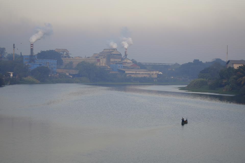 Smokestacks spew fumes from chemical industries located along the banks of the Periyar River in Eloor, Kerala state, India, Friday, March 3, 2023. Residents have risen up against the factories contaminating the river in the area. (AP Photo)