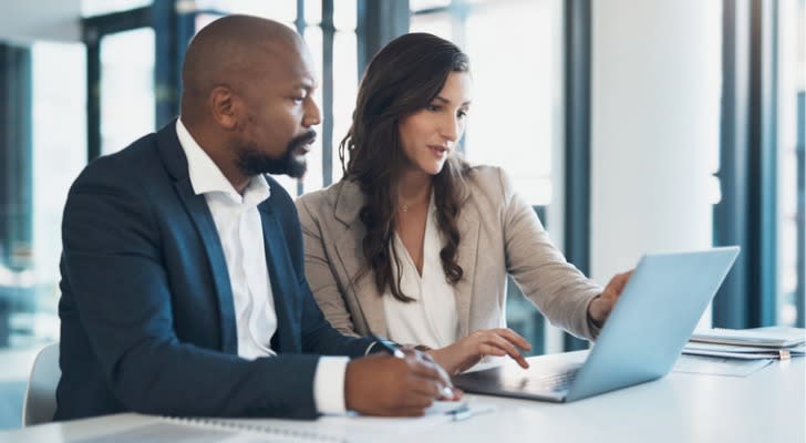 Two financial advisors researching the requirements for a CFP certification.