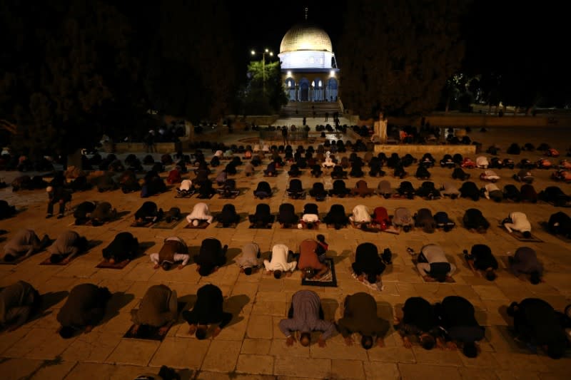 Worshippers pray in front of the Dome of the Rock in the compound known to Muslims as Noble Sanctuary and to Jews as Temple Mount in Jerusalem's Old City, after it was reopened following a coronavirus closure