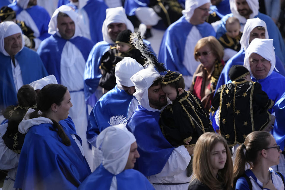 Faithful walk with their babies during a procession in Procida Island, Italy, Friday, March 29, 2024. Italy is known for the religious processions that take over towns big and small when Catholic feast days are celebrated throughout the year. But even in a country where public displays of popular piety are a centuries-old tradition, Procida's Holy Week commemorations stand out. (AP Photo/Alessandra Tarantino)